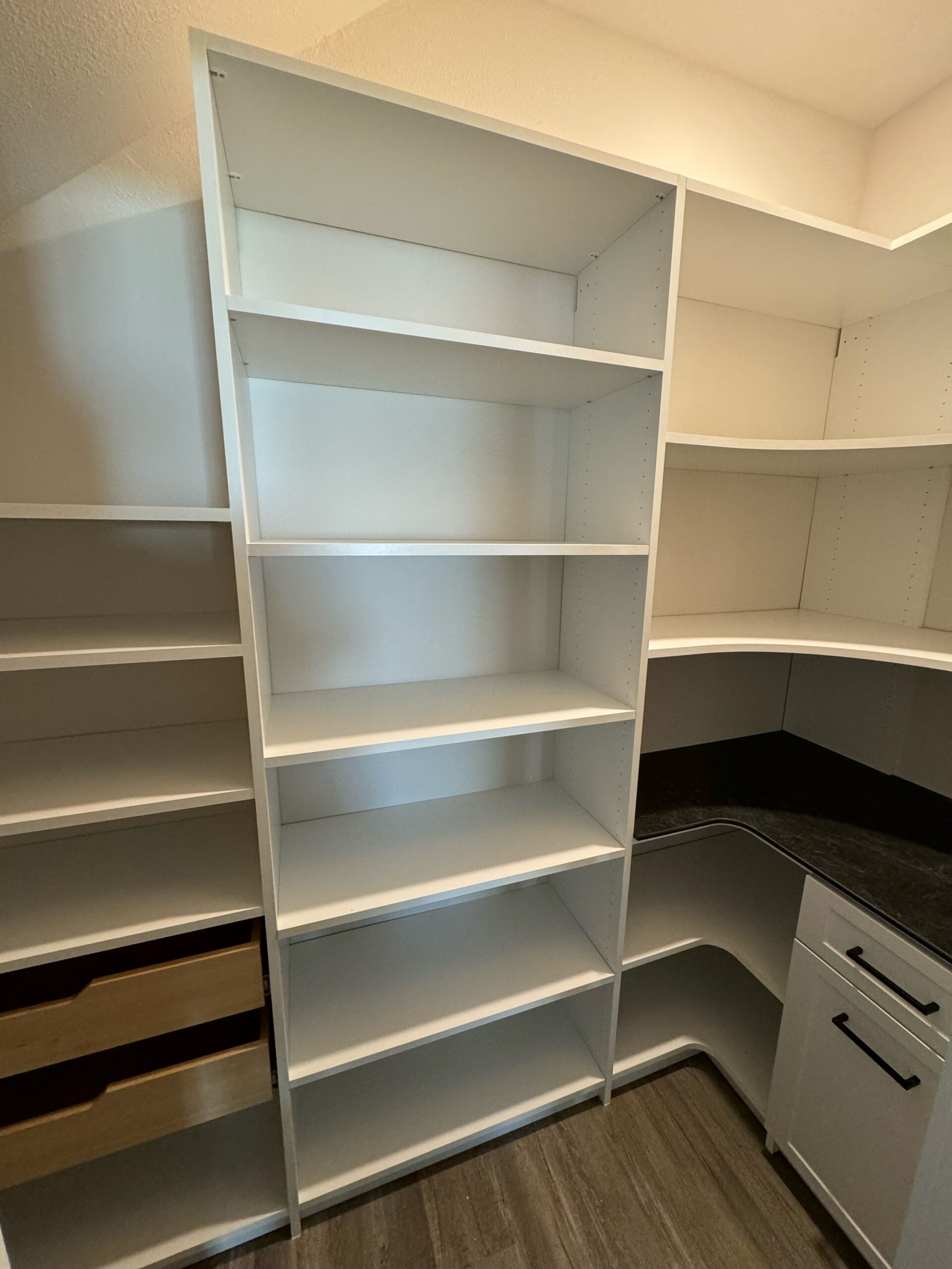 White pantry with wood pull-outs, a Thinscape counter, and corner shelving